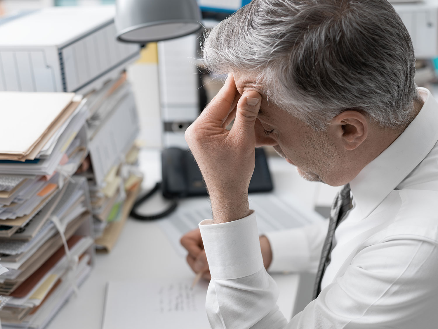Businessman working in the office and piles of pap