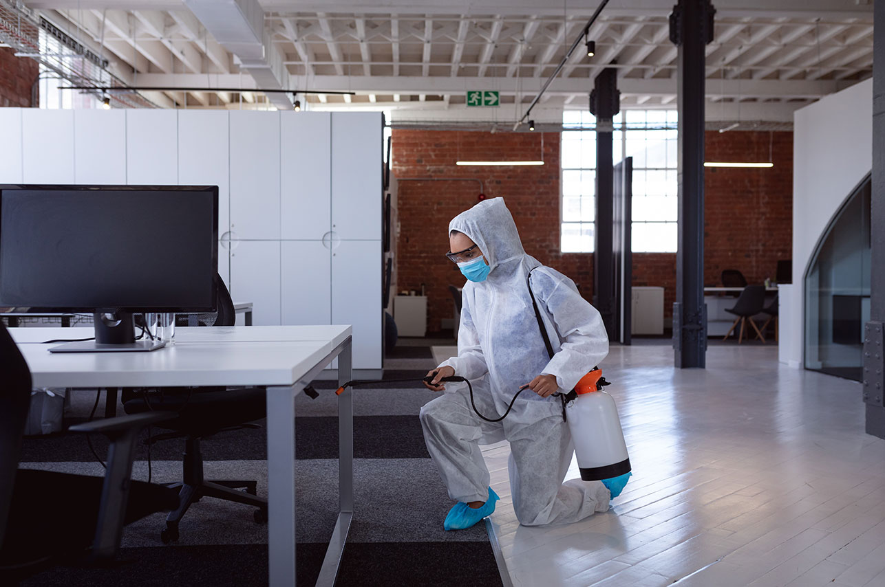 Cleaner wearing ppe suit glasses and mask disinfe