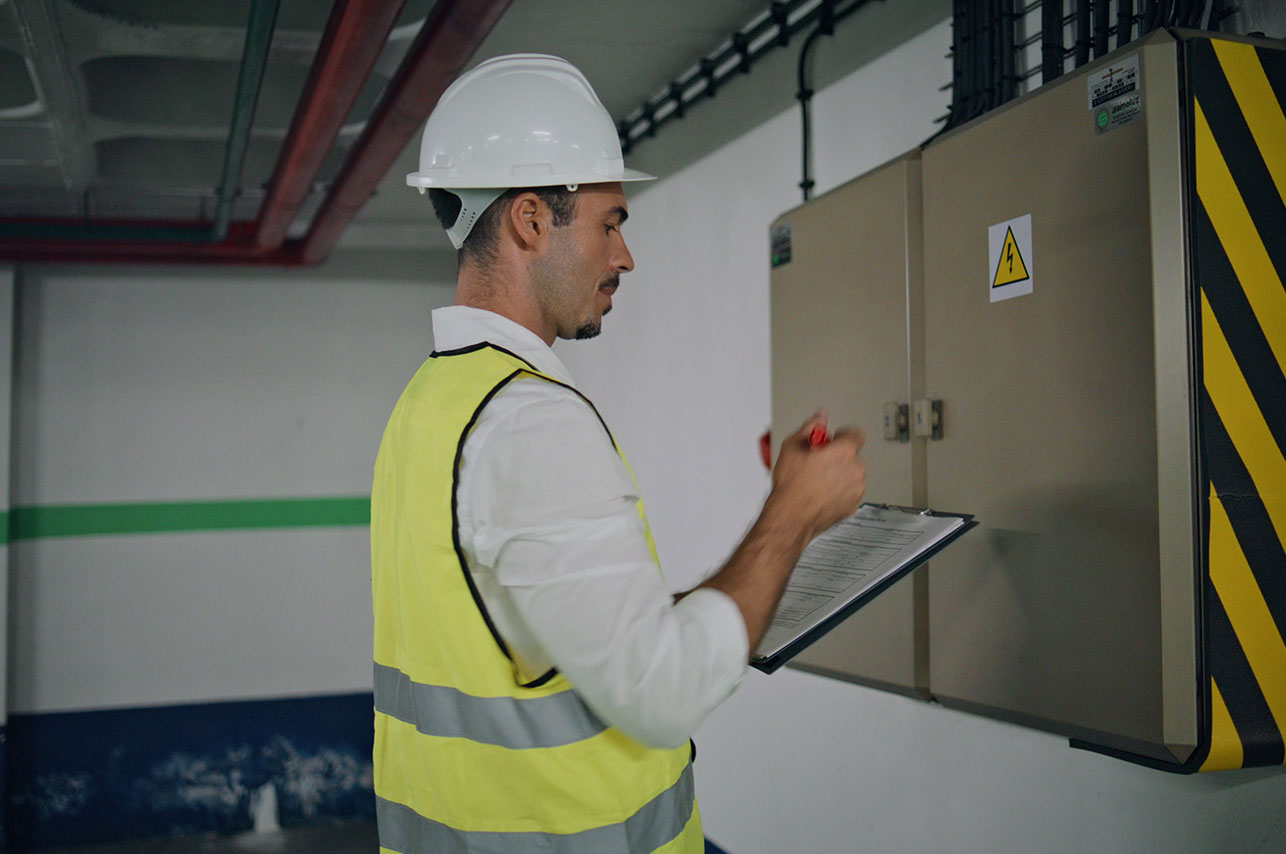 Uniform electrician checking panel making notes